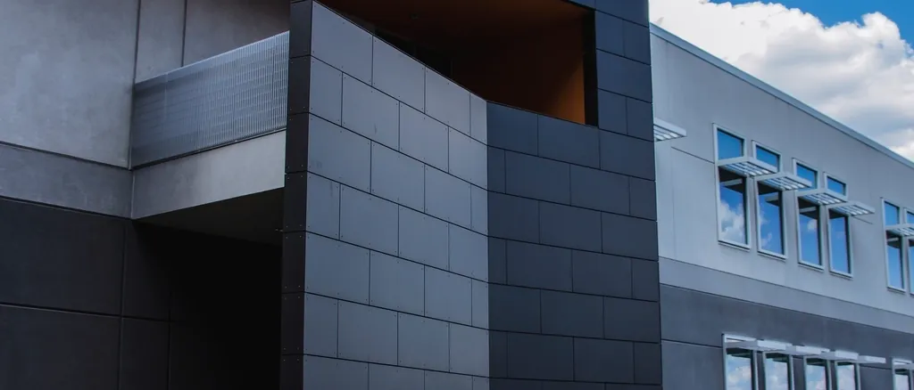 Dark panelled facade of a contemporary building against the sky