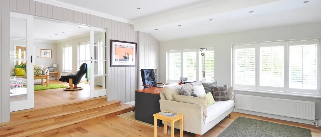 Open-plan living space with timber floors and garden windows